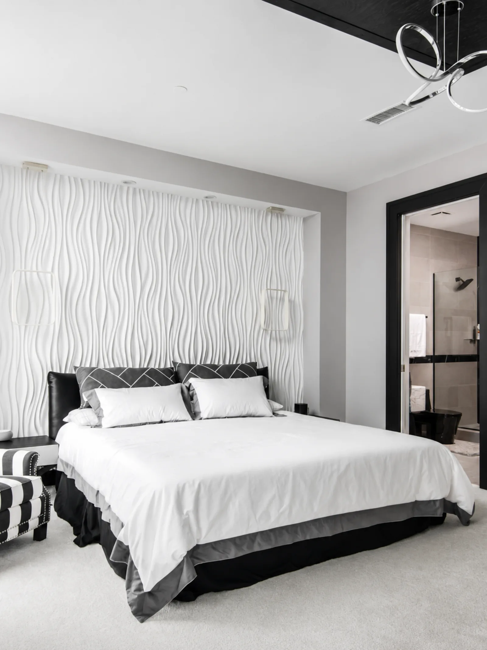 Guest bedroom with a wavy textured headboard wall in black and white