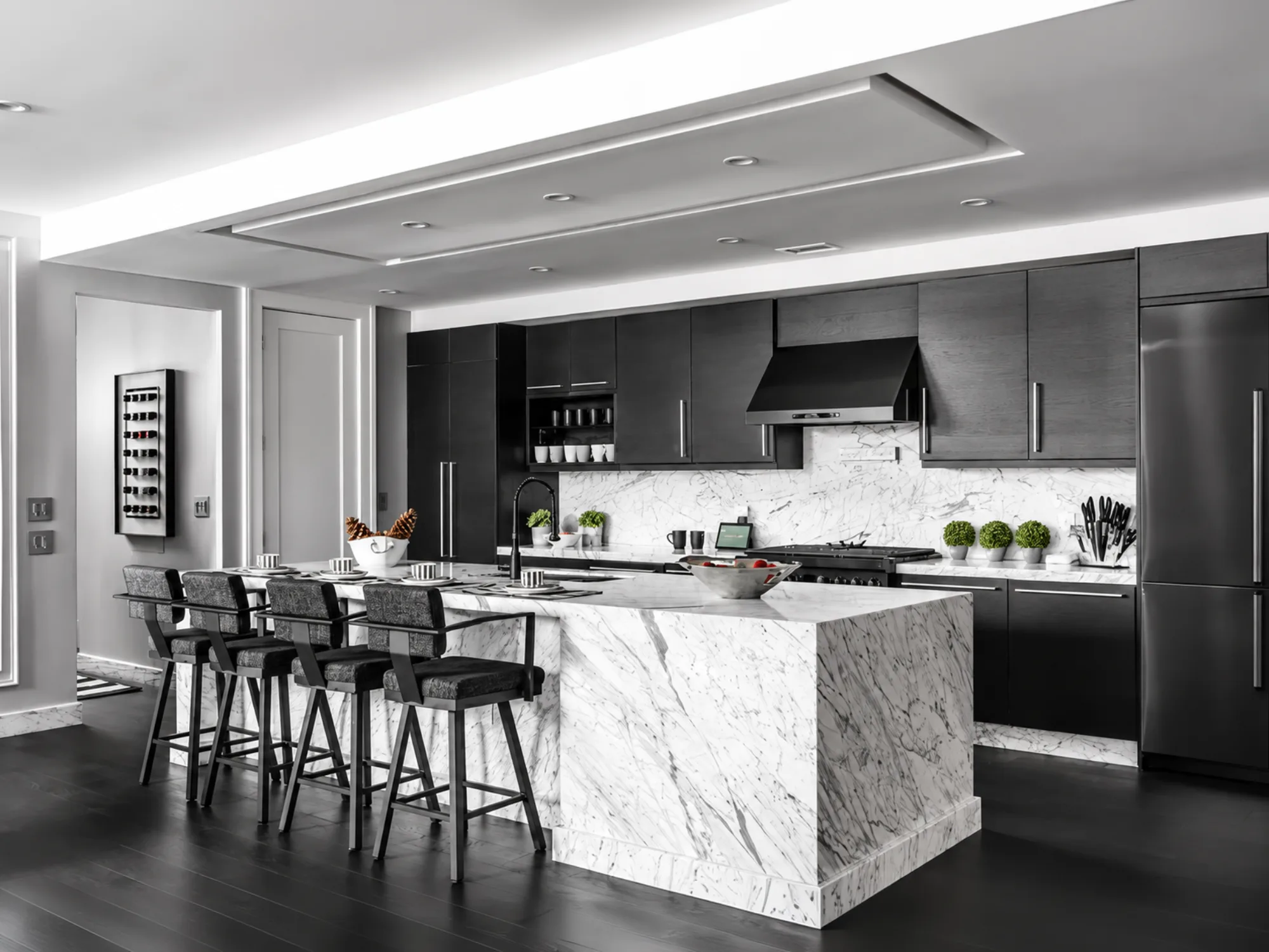 Marble waterfall-island kitchen with dark cabinetry