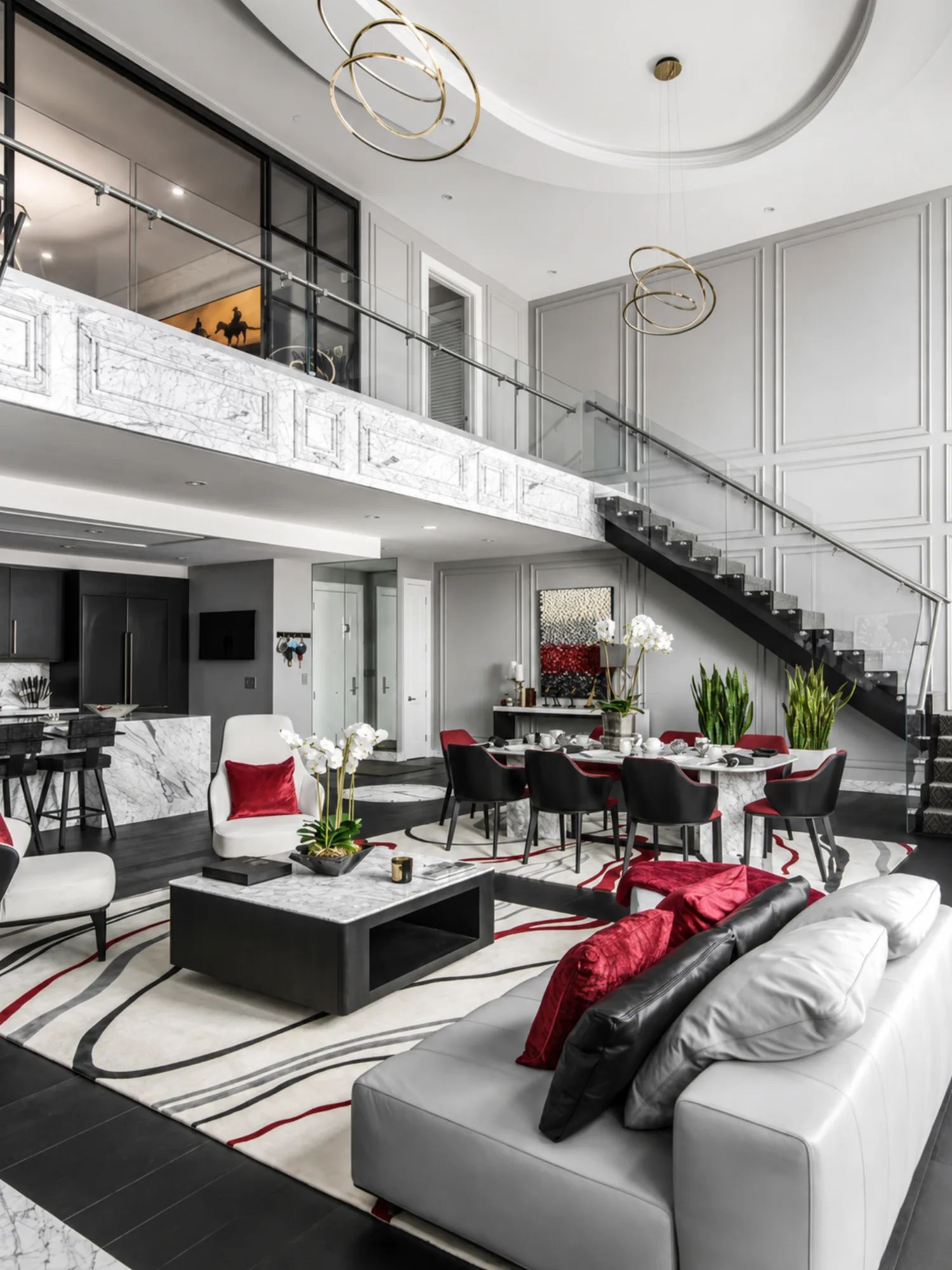 Living and dining areas seen from the mezzanine, with marble and red accents