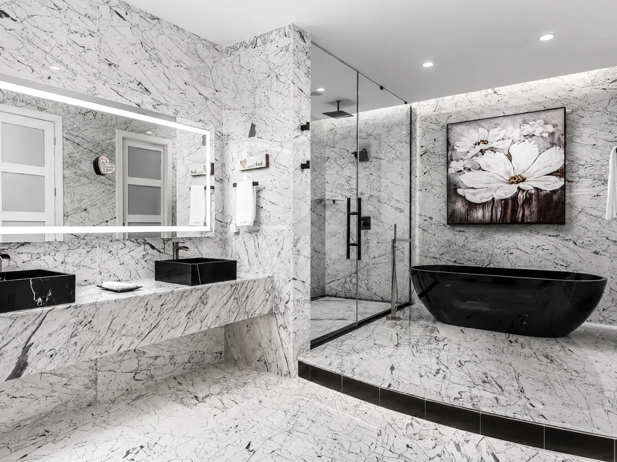 Full-marble primary bath with a black freestanding tub and floral art